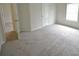 Bright bedroom with neutral carpet, white walls, and a door leading to another room at 2289 Overlook Ave, Lithonia, GA 30058