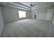 Expansive bedroom features a tray ceiling, neutral carpet, and natural light from the bright window at 2289 Overlook Ave, Lithonia, GA 30058