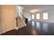 Welcoming living room featuring dark hardwood floors, staircase, and ample natural light at 2289 Overlook Ave, Lithonia, GA 30058