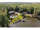 Stunning aerial view of a lakeside property with a luxurious home, swimming pool, boat dock, and lush greenery at 4095 E Highway 166 Hwy, Carrollton, GA 30116
