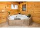 Relaxing bathroom featuring a large soaking tub, wood paneled walls, and natural light creates a spa-like oasis at 4095 E Highway 166 Hwy, Carrollton, GA 30116