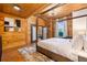 Bright bedroom featuring a wooden four-poster bed and view of trees and blue sky at 4095 E Highway 166 Hwy, Carrollton, GA 30116