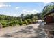 Driveway with lush landscaping leading to the stunning waterfront property with mature trees at 4095 E Highway 166 Hwy, Carrollton, GA 30116