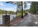 Scenic driveway leading to the waterfront home, showcasing mature trees and a lake view at 4095 E Highway 166 Hwy, Carrollton, GA 30116