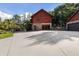 Exterior view of the log cabin style home with stone accents, a large driveway, and mature trees at 4095 E Highway 166 Hwy, Carrollton, GA 30116