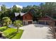 Exterior view of this log cabin style home with a large driveway and mature trees at 4095 E Highway 166 Hwy, Carrollton, GA 30116