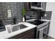 Modern kitchen featuring sleek gray backsplash, stainless steel appliances, and stylish fixtures at 4095 E Highway 166 Hwy, Carrollton, GA 30116
