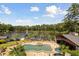 Backyard view featuring an in-ground pool, a jacuzzi, and an outdoor kitchen facing a serene lake at 4095 E Highway 166 Hwy, Carrollton, GA 30116