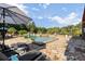 Outdoor pool area with stone patio, comfortable lounge chairs, and lush greenery, ideal for entertaining at 4095 E Highway 166 Hwy, Carrollton, GA 30116