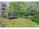Grassy backyard featuring a trampoline, surrounded by lush trees and greenery at 4842 Registry Nw Dr, Kennesaw, GA 30152