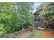 Landscaped backyard featuring a screened porch, wooden deck and stairs, and mature trees at 4842 Registry Nw Dr, Kennesaw, GA 30152