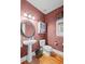 A quaint powder room featuring textured walls, a pedestal sink, and warm-toned hardwood floors at 4842 Registry Nw Dr, Kennesaw, GA 30152