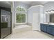 Primary bath with a large soaking tub, glass shower, vanity with storage and blue cabinets at 4842 Registry Nw Dr, Kennesaw, GA 30152
