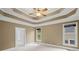 Bedroom with a tray ceiling, fan, and a neutral carpet and walls and large windows at 4842 Registry Nw Dr, Kennesaw, GA 30152