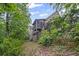 Rear exterior view of home featuring a screened porch and wooded surroundings at 4842 Registry Nw Dr, Kennesaw, GA 30152