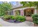 Inviting brick home features a covered front porch with double doors and lush landscaping at 4842 Registry Nw Dr, Kennesaw, GA 30152