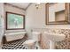 Charming bathroom featuring a clawfoot tub, patterned wallpaper, and black and white tile floors at 510 Aiken Dr, Dallas, GA 30157