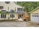 Cream-colored two-story house with black shutters, a detached garage and a wooden staircase leading to the front door at 510 Aiken Dr, Dallas, GA 30157