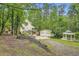 Landscaped yard featuring a charming home, detached garage, and gazebo surrounded by lush greenery at 510 Aiken Dr, Dallas, GA 30157