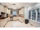 Bright eat-in kitchen featuring white cabinetry, stainless steel appliances, and a large window overlooking the backyard at 510 Aiken Dr, Dallas, GA 30157