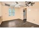 A simple room with dark wood floors, a ceiling fan, and a large window at 510 Aiken Dr, Dallas, GA 30157