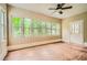 Well-lit sunroom featuring hardwood floors, paneled walls, white trim, and multiple windows with views to the trees outside at 510 Aiken Dr, Dallas, GA 30157
