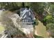 Aerial view of the expansive home featuring a multi-car garage, circular driveway, and lush wooded surroundings at 5360 Northwater Way, Duluth, GA 30097