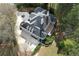 Aerial view of the expansive home featuring an outdoor deck, circular driveway, and well-manicured lawns at 5360 Northwater Way, Duluth, GA 30097