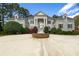 Grand home showcasing symmetrical architecture, prominent columns, and a beautiful statue centered in the circular driveway at 5360 Northwater Way, Duluth, GA 30097