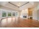 Open living room with hardwood floors, fireplace, built-in shelving, and large windows with views of the backyard at 5360 Northwater Way, Duluth, GA 30097