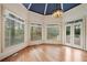 Bright sunroom with a chandelier and hardwood floors, leading to a private outdoor deck at 5360 Northwater Way, Duluth, GA 30097