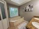 Bathroom features a jetted tub next to a large window and granite countertop vanity at 910 Kings Arms Way, Alpharetta, GA 30022