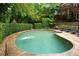 A large swimming pool with surrounding stone and mature landscaping that offers a private and relaxing outdoor space at 910 Kings Arms Way, Alpharetta, GA 30022