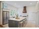Modern kitchen island with counter seating, stainless appliances, and a custom vent hood at 95 Whitlock Sw Ave, Marietta, GA 30064