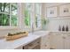 Modern kitchen featuring white countertops, a farmhouse sink, and a view of the backyard at 95 Whitlock Sw Ave, Marietta, GA 30064