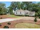 Rear exterior view of home with a well-manicured lawn and gravel driveway at 95 Whitlock Sw Ave, Marietta, GA 30064
