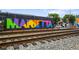Colorful 'Marietta' mural adds vibrant character to the urban landscape near train tracks at 95 Whitlock Sw Ave, Marietta, GA 30064