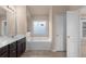 Primary bathroom featuring a soaking tub, vanity, and window with natural light at 1212 Lake Point Way, Suwanee, GA 30024