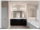 Bright bathroom featuring double sinks, vanity lighting, and a luxurious soaking tub at 1212 Lake Point Way, Suwanee, GA 30024