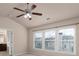 Bright bedroom featuring a ceiling fan and a window with blinds allowing natural light at 1212 Lake Point Way, Suwanee, GA 30024