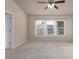 Carpeted bedroom featuring a ceiling fan and a window with blinds allowing natural light at 1212 Lake Point Way, Suwanee, GA 30024