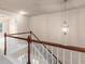 Hallway boasting dark wood and white railings with hanging ornate lighting fixture at 1212 Lake Point Way, Suwanee, GA 30024