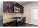 Modern kitchen featuring stainless steel appliances, granite countertops, and stylish dark wood cabinets at 1212 Lake Point Way, Suwanee, GA 30024