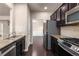Well-equipped kitchen with stainless steel appliances, granite counters, dark cabinets, and an adjacent dining area at 1212 Lake Point Way, Suwanee, GA 30024