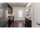 Updated kitchen with dark cabinetry, stainless steel appliances, granite countertops, and access to the backyard at 1212 Lake Point Way, Suwanee, GA 30024