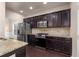 Gourmet kitchen with dark cabinets, stainless appliances, granite countertops, and tile backsplash at 1212 Lake Point Way, Suwanee, GA 30024