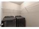 Laundry room with black washer and dryer and white wire shelving at 1212 Lake Point Way, Suwanee, GA 30024