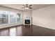 Spacious living room with hardwood floors, a ceiling fan, and a fireplace with a white mantle at 1212 Lake Point Way, Suwanee, GA 30024