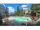A community pool surrounded by lounge chairs, umbrellas, and green trees at 1250 Parkwood Cir # 2112, Atlanta, GA 30339