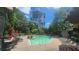 A community pool with lounge chairs and umbrellas surrounded by green trees at 1250 Parkwood Cir # 2112, Atlanta, GA 30339